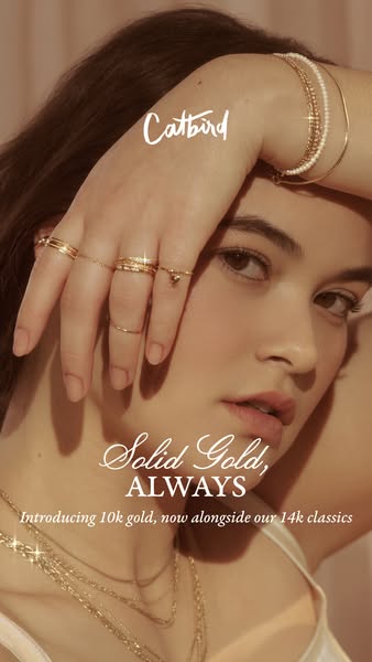 This ad features a close-up shot of a woman wearing several pieces of Catbird jewelry, including rings on her fingers, b