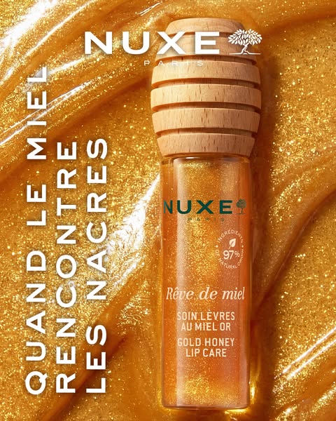 This ad showcases the Nuxe Reve de Miel Gold Honey Lip Care. The advertisement places the product against a background o