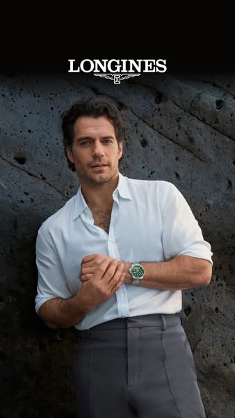 An image ad showcasing a Longines watch worn by Henry Cavill, positioned against a rocky background. The brand logo is p