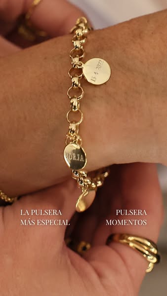 The ad showcases a gold charm bracelet with a focus on personalization. The bracelet features circular charms, one engra