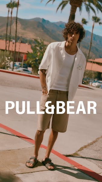 This ad for Pull&Bear features a stylish young man in a casual summer outfit standing on a city street. The image hi