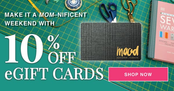 Ad for Mood Fabrics offering 10% off eGift cards for a 'Mom-Nificent' weekend, set against a crafting background