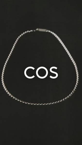 This ad features a simple yet elegant necklace. The silver chain is displayed against a dark background. The brand name 