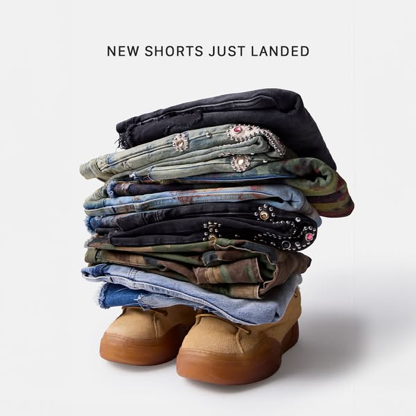 The ad features a stack of denim shorts balanced on top of shoes and the text "NEW SHORTS JUST LANDED".