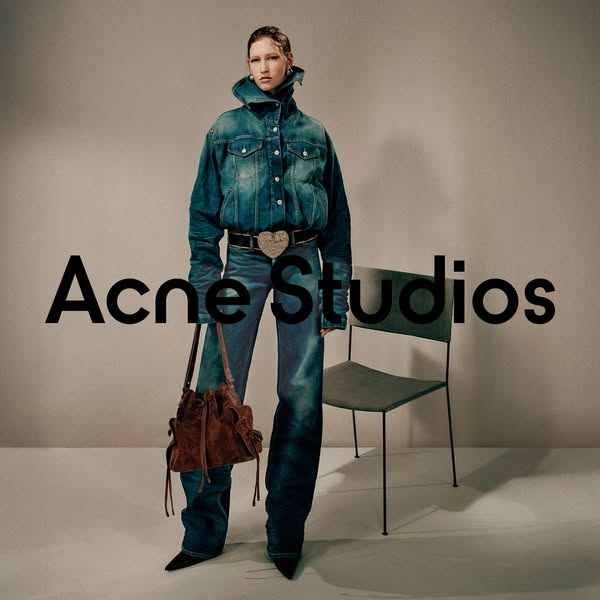 This ad showcases a model wearing Acne Studios clothing and accessories. The ad is a simple studio shot with the brand n