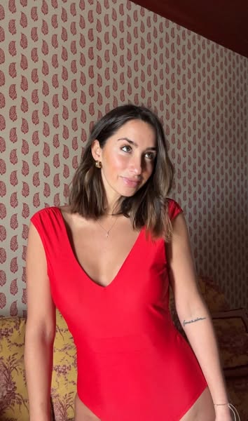 This ad features a woman modeling a red swimsuit. It is a product demo of how the swimsuit looks on a person.