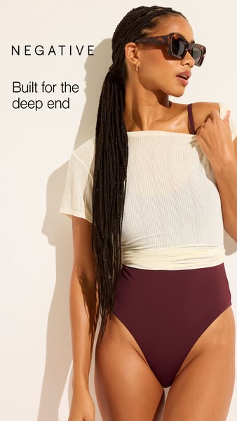 This ad features a woman modeling a Negative brand swimsuit and tee-shirt. The ad focuses on the idea of wearing swimwea