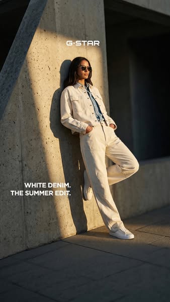 This ad features a woman leaning against a textured concrete wall wearing pieces from G-Star's white denim summer ed