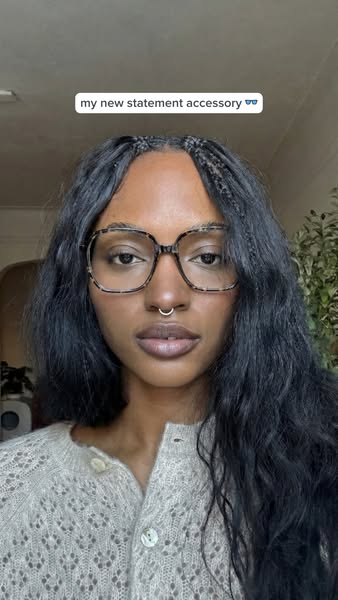 A woman shows off a new pair of fashionable eyeglasses.