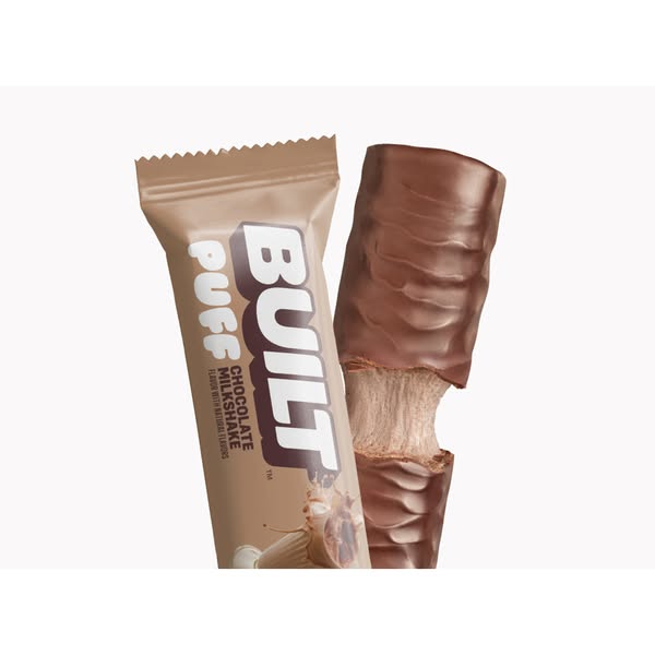 This ad features a close-up of a Built protein bar, emphasizing its chocolate milkshake flavor and appealing to those se