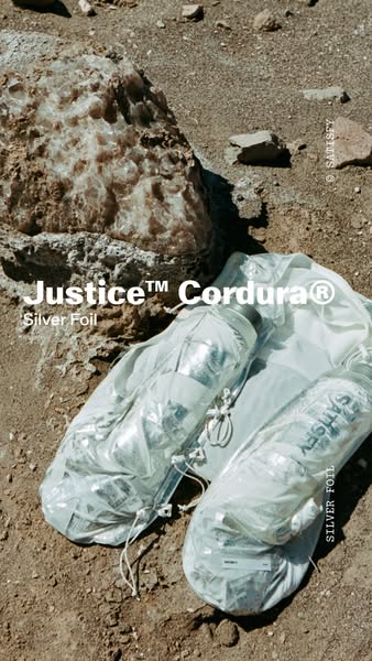 This ad displays two Satisfy brand products with silver foil. The products, which are placed on rocks and sand, include 