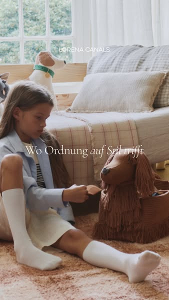 This ad features a young girl sitting in front of a toy bed holding a small wooden item and next to a large dog-shaped w