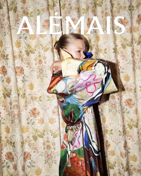 This ad features a young model wearing a bright, patterned dress. The background is made of matching floral print fabric