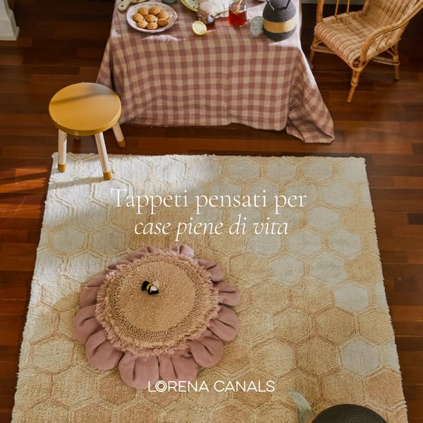 This ad showcases a Lorena Canals washable rug with a honeycomb pattern, styled in a cozy home setting.