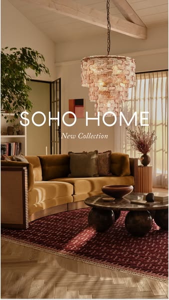 This image ad for SOHO HOME features a stylishly decorated living room with a plush sectional sofa, a unique coffee tabl