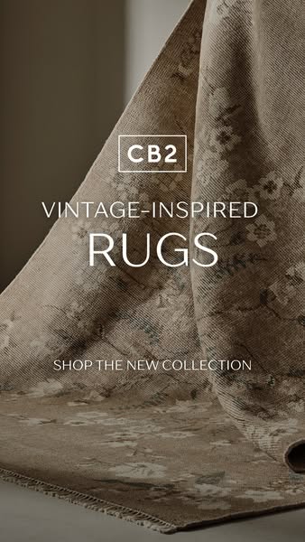 An ad for CB2 vintage-inspired rugs. The image focuses on the texture and design of the rug, with text overlay that incl