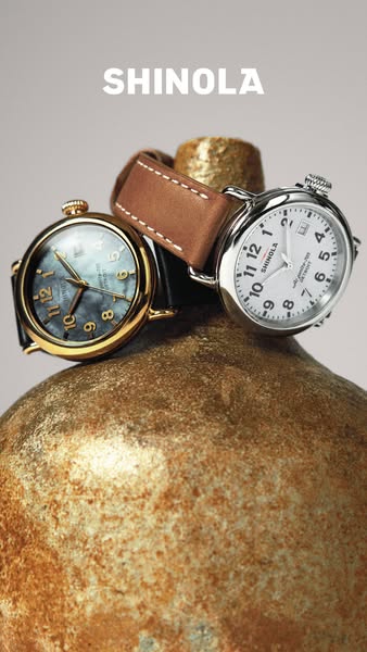 This ad features two different watches that are stacked on top of a golden surface with the brand name above the product