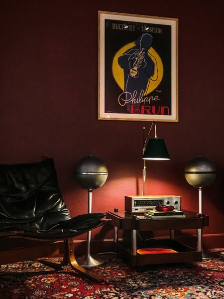 This image shows a listening room with an ergonomic chair, speakers, and a stereo receiver. The overall impression is of