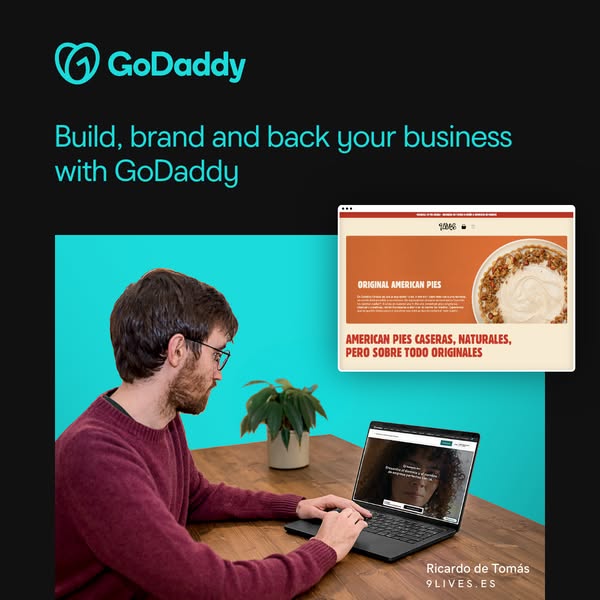 This image ad for GoDaddy features a man working on a laptop at a wooden desk. The ad promotes GoDaddy's services fo