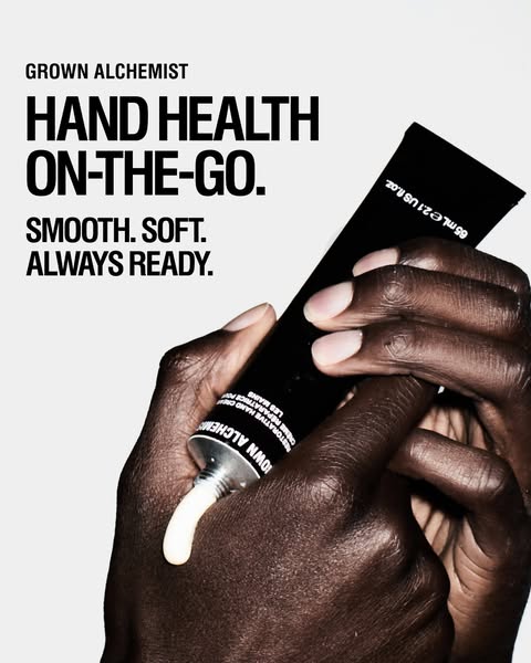 An ad for Grown Alchemist hand cream featuring a person squeezing the product from its tube.