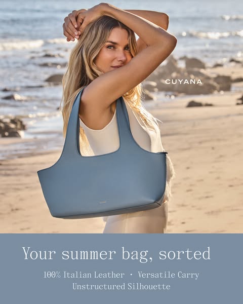 This ad showcases a woman on the beach carrying a light blue leather bag from Cuyana, emphasizing its style and quality 