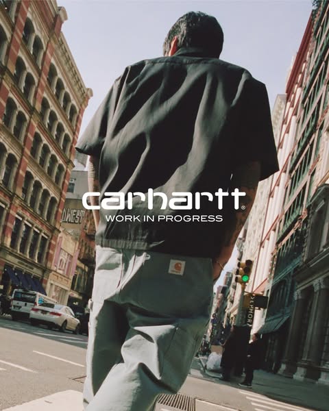 Image promoting Carhartt Work in Progress apparel. The photo shows a person wearing the apparel while walking down a cit