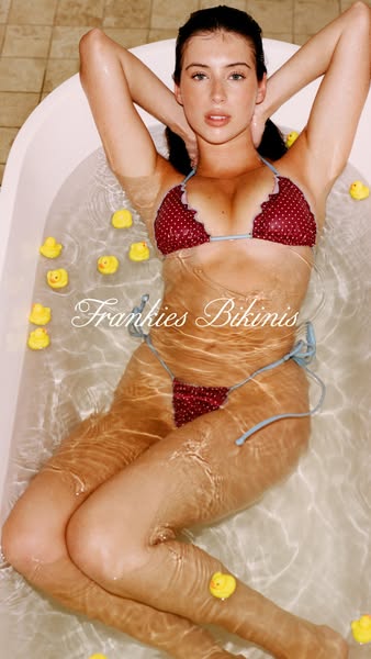 An image ad of a model in a bathtub filled with rubber ducks. She is wearing a Frankie's Bikinis brand bikini. The b