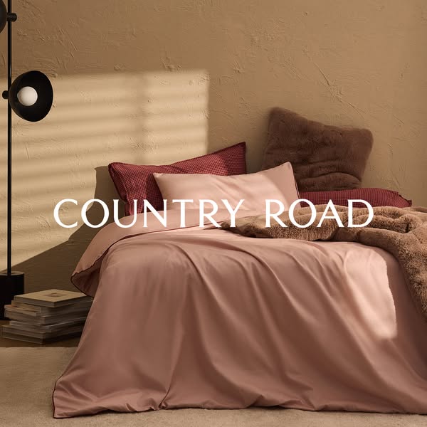 This ad showcases Country Road's bedding set in a staged room, emphasizing the brand's name as a prominent desig