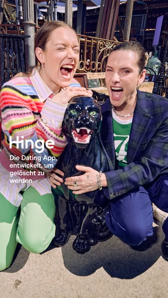 This image ad features two friends smiling while holding a black panther statue. The ad promotes the dating app Hinge.
