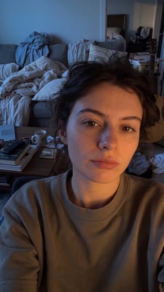 A person is taking a selfie-style testimonial shot in their home.
