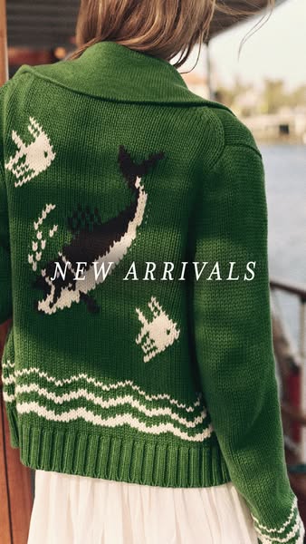 This image ad highlights a green cardigan sweater with white fish and whale designs.