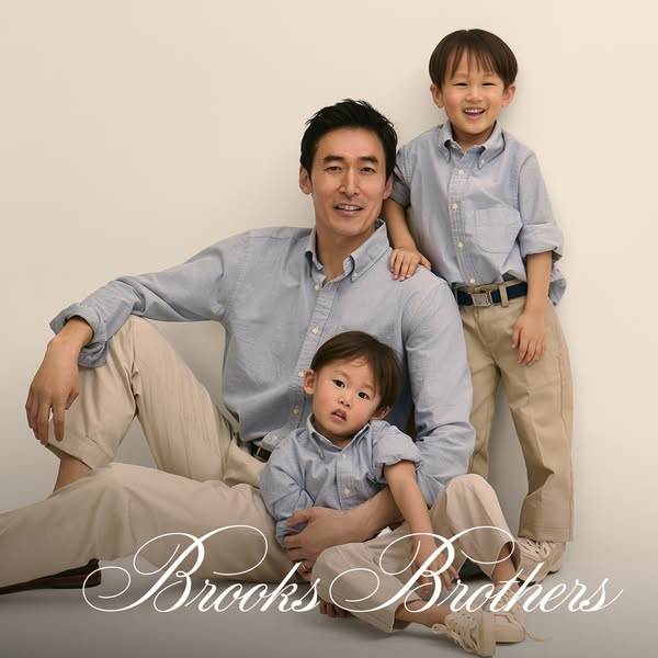 This ad features a portrait of an Asian father and two young sons dressed in light-blue button-down shirts and khaki pan