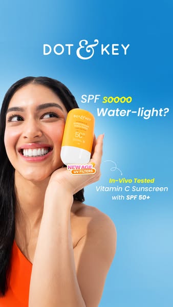 A close up shot of a woman holding a bottle of Dot & Key sunscreen, calling out the light weight formula and high SP