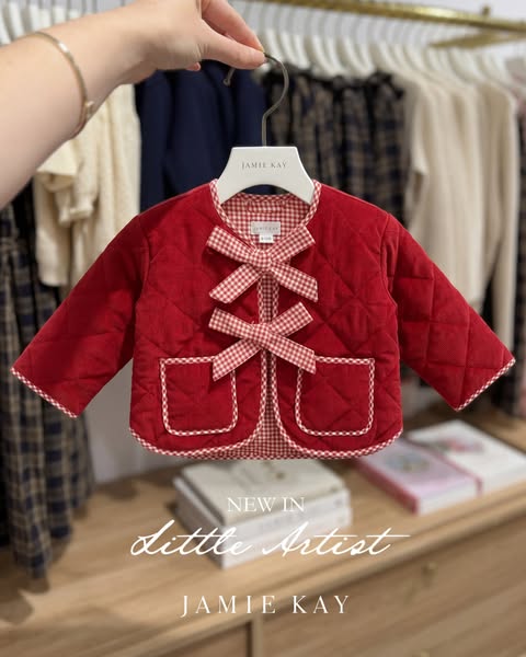 This ad showcases a red gingham coat by Jamie Kay. The ad features a product-forward approach, focusing on a single, vis