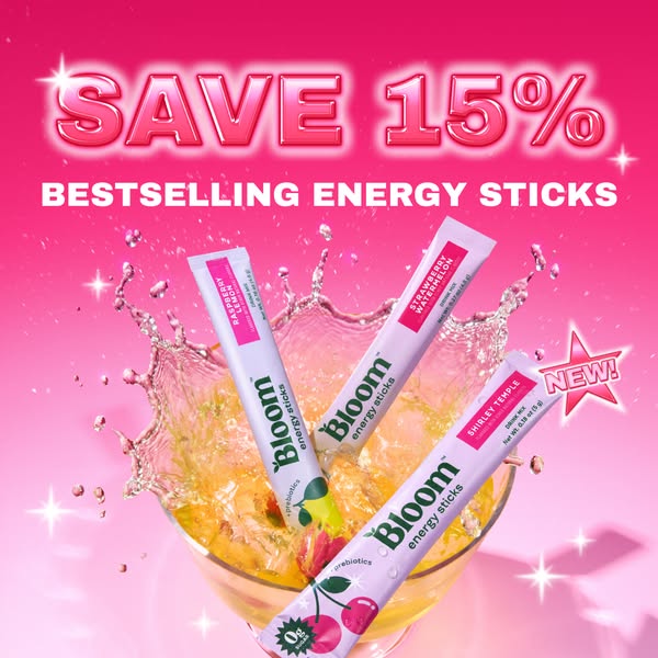 This ad for Bloom Nutrition features three Bloom Energy Sticks against a pink background with a splashing cocktail. The 