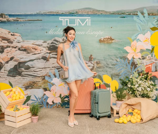 This ad features a woman standing in front of a backdrop promoting Tumi luggage. Crates of lemons and floral arrangement