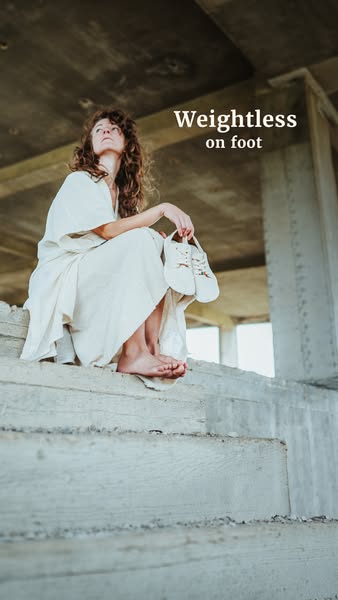 This ad features a model sitting on concrete steps with a pair of shoes in her hand and barefoot. The text overlay indic
