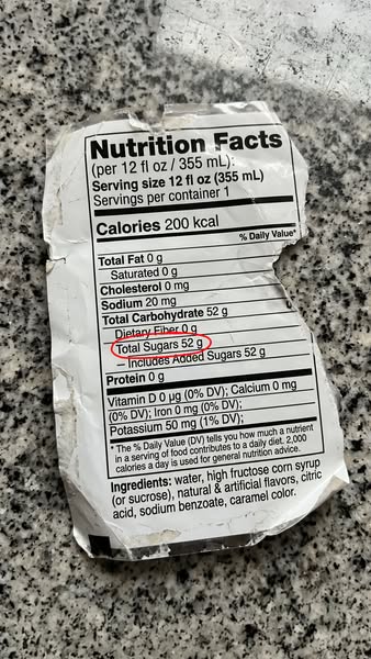 This ad highlights the high sugar content in a typical drink by showcasing the nutrition facts label of a sugary beverag
