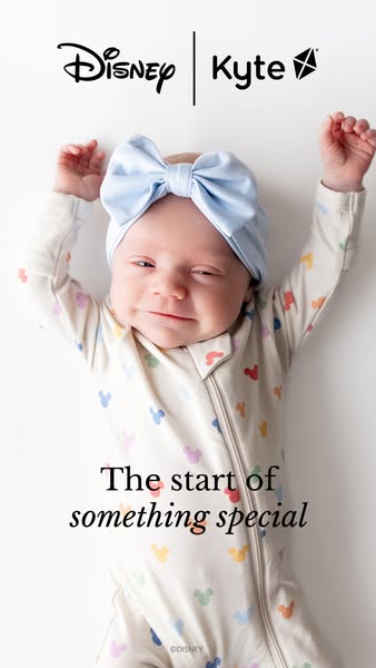 An image ad showing a baby lying on a white surface wearing a Mickey Mouse patterned pajama and a light blue bow. The ad