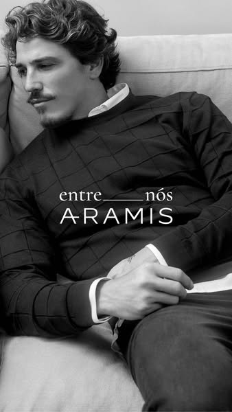 This image ad showcases Aramis menswear. The ad features a man reclining on a couch wearing Aramis clothing. The image i