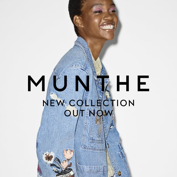 This image ad for Munthe features a smiling model wearing a denim jacket from the brand's new collection, set agains