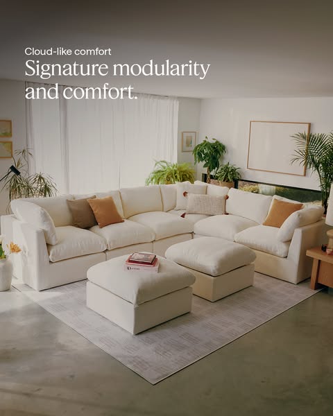 The ad showcases a large, modular white couch in a well-lit living space, emphasizing its cloud-like comfort and signatu