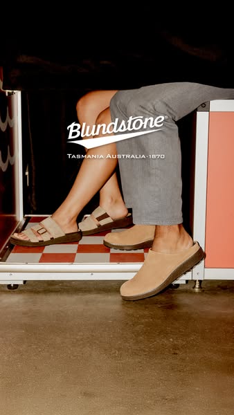 This image ad displays two models wearing Blundstone shoes. The models are sitting close together, showcasing a sandal a