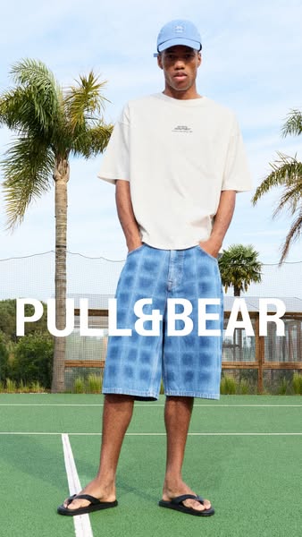 An image ad featuring a model wearing a Pull&Bear outfit, consisting of a t-shirt, plaid shorts, and a cap, against 