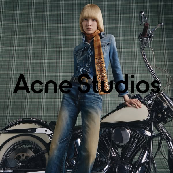 This image ad features a model leaning against a motorcycle, wearing Acne Studios clothing. The ad emphasizes the brand&
