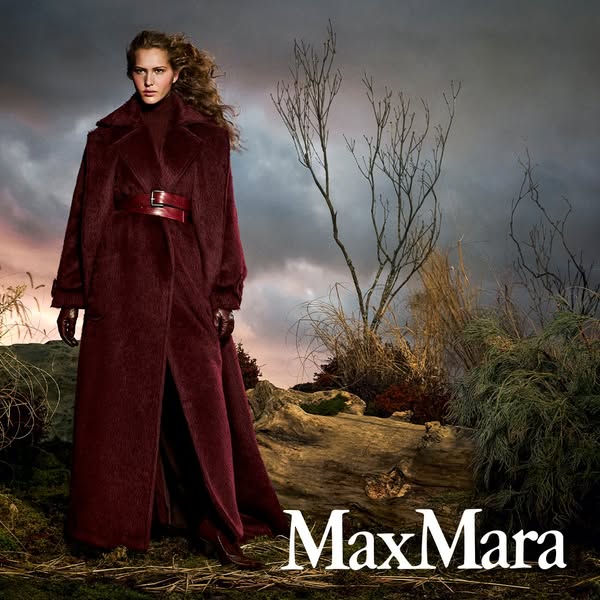 This ad features a woman wearing a long, red Max Mara coat in an outdoor setting. The ad focuses on the coat's luxur