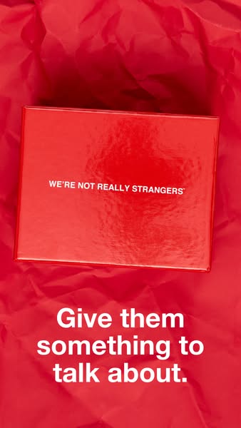 This ad features the We're Not Really Strangers card game. The ad is a close up of the game box on a red background 