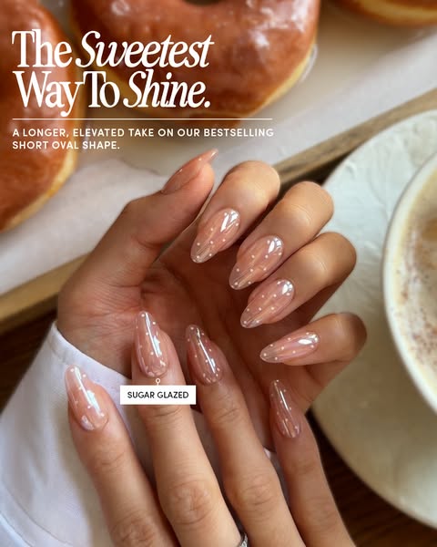 This ad showcases a hand with long, oval-shaped nails painted in a 'Sugar Glazed' color, set against a backdrop 