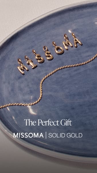 This ad showcases Missoma's solid gold initial pendants and chain, emphasizing their suitability as a gift.