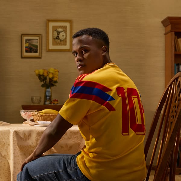 This ad features a person sitting at a table while wearing an Adidas Colombia soccer jersey. The image is framed in an i